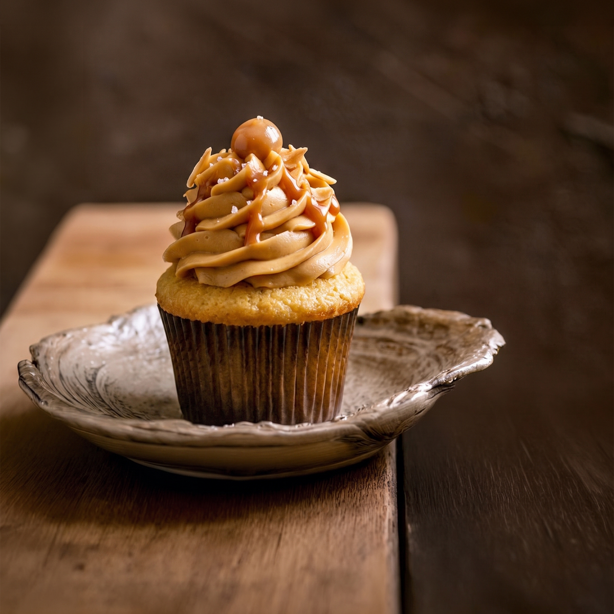 Caramel Buttercream fragrance artwork with a caramel-frosted cupcake and caramel drizzle on a ceramic plate.