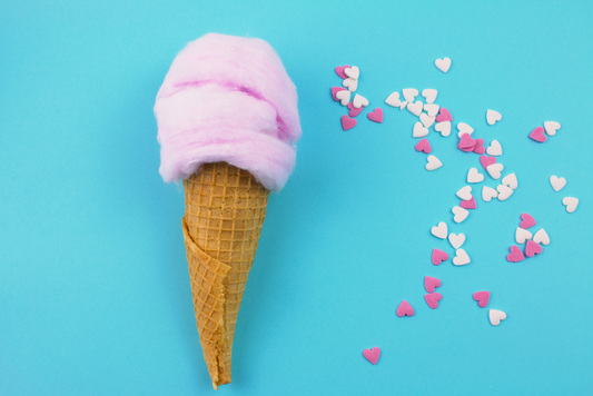 a pink ice cream cone with hearts on a blue background